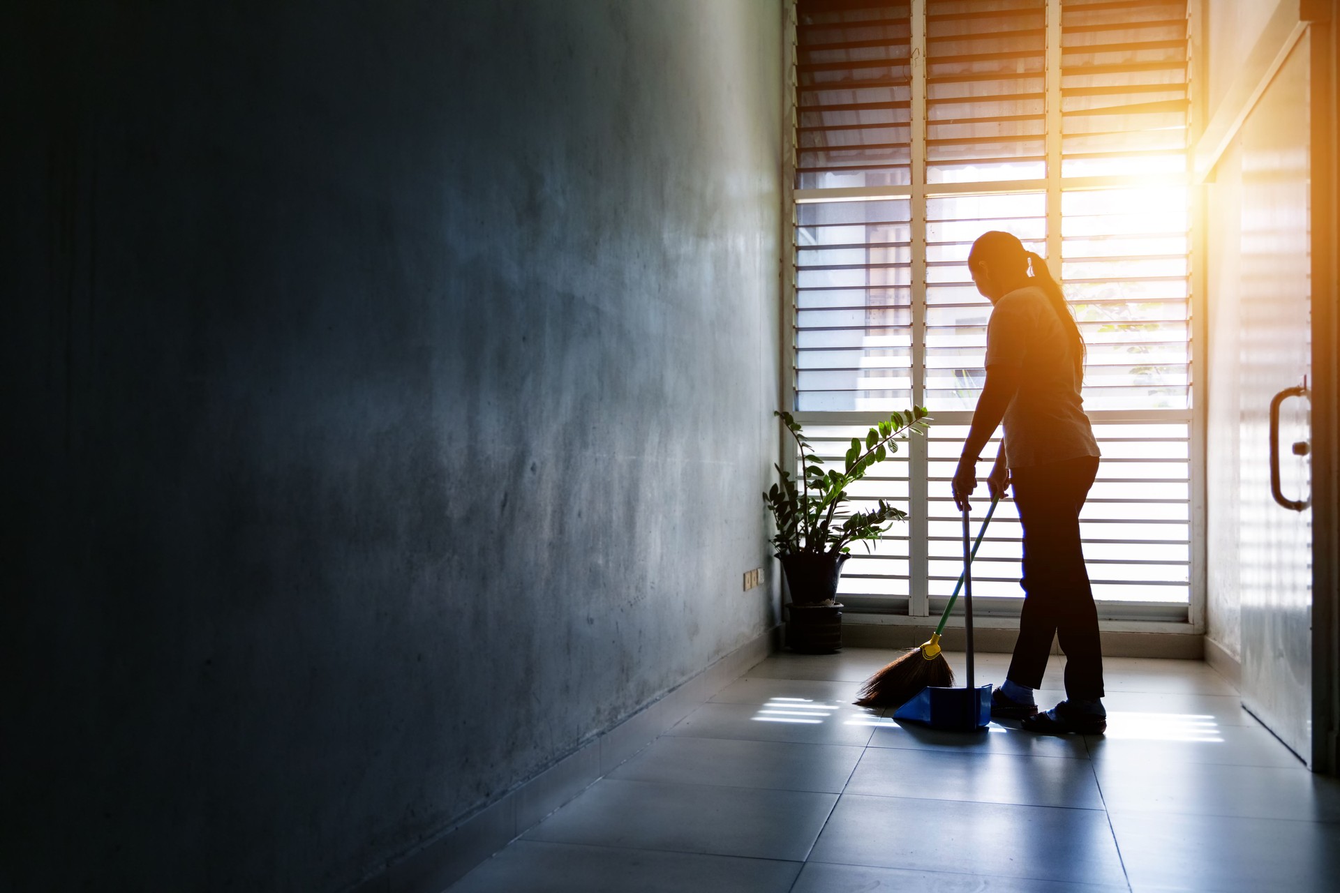 Janitor woman sweep the floor in hallway office building or walkway after school or classroom with blank copy space.